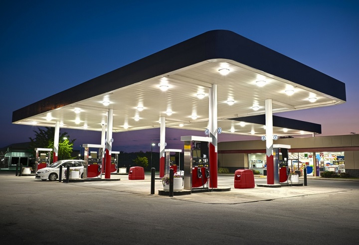 Posto de combustível automatizado à noite, com pista e bombas iluminadas